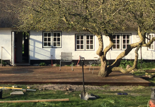 A wooden deck build around an apple tree with GroundPlug® TwisterTM Screw Piles.